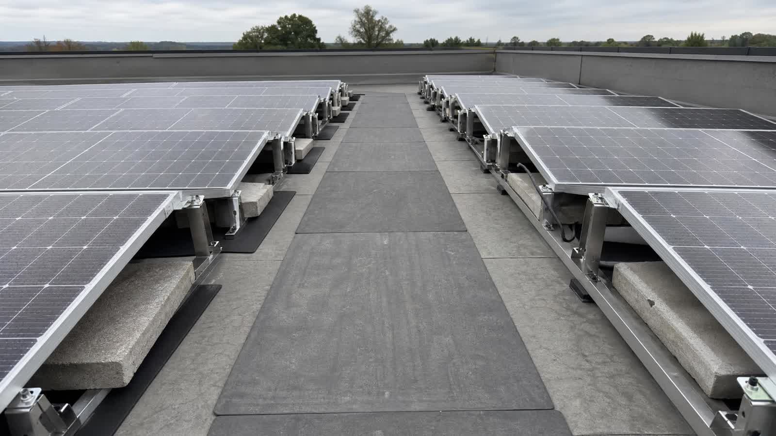 Wartungsweg zwischen PV-Modulen auf einem Flachdach mit verdeckten Dachbereichen